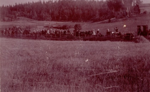 Historisk svartvit bild av ett tåg med gäster som anländer till Fiskars för Albert och Sophie von Julins silverbröllop 1894. Orkestern syns i första vagnen.